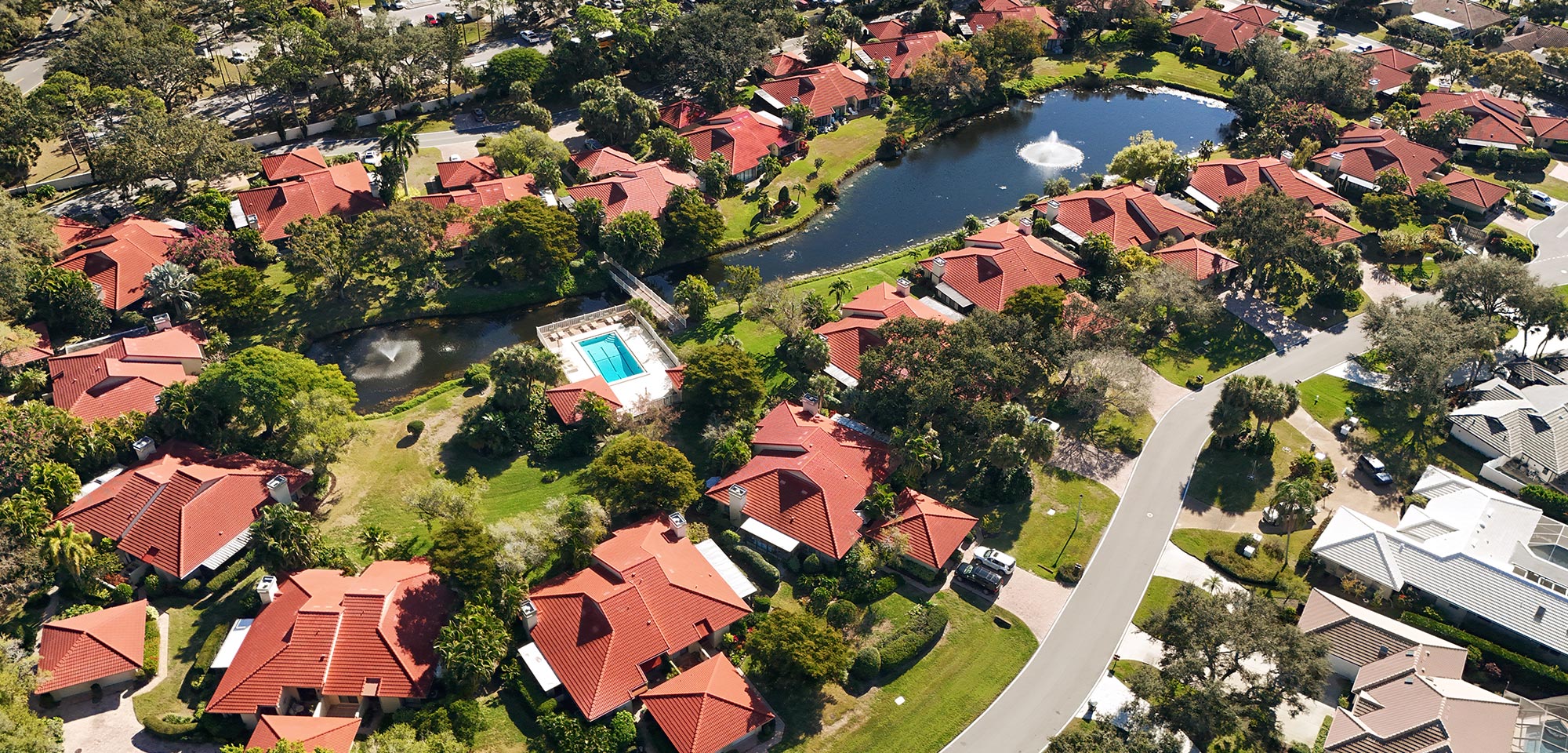 Aerial view of Carriagehouse condos with pool and lake