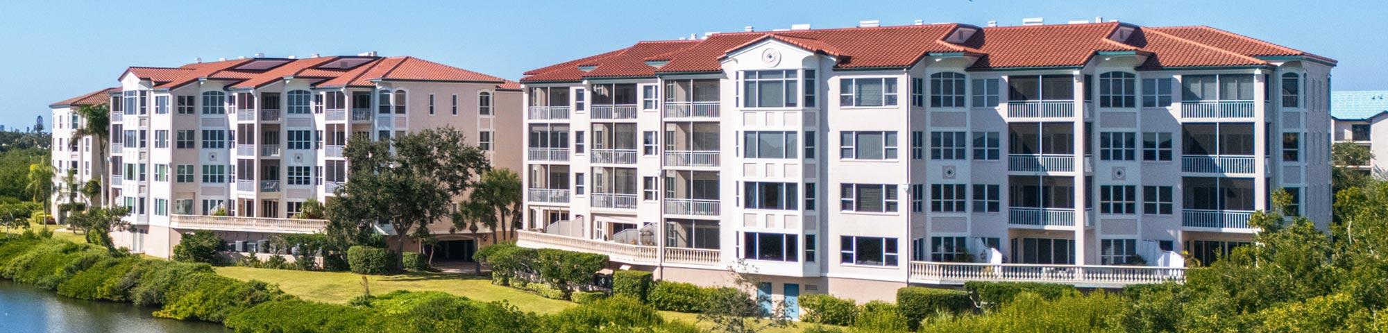 Roof high aerial view of Eagles Point mid-rise condos from Phillippi Creek