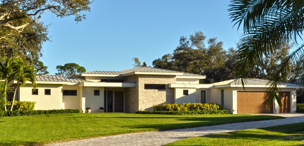 Street view of Florida contemporary style single family home with low pitched roof and stone accent wall